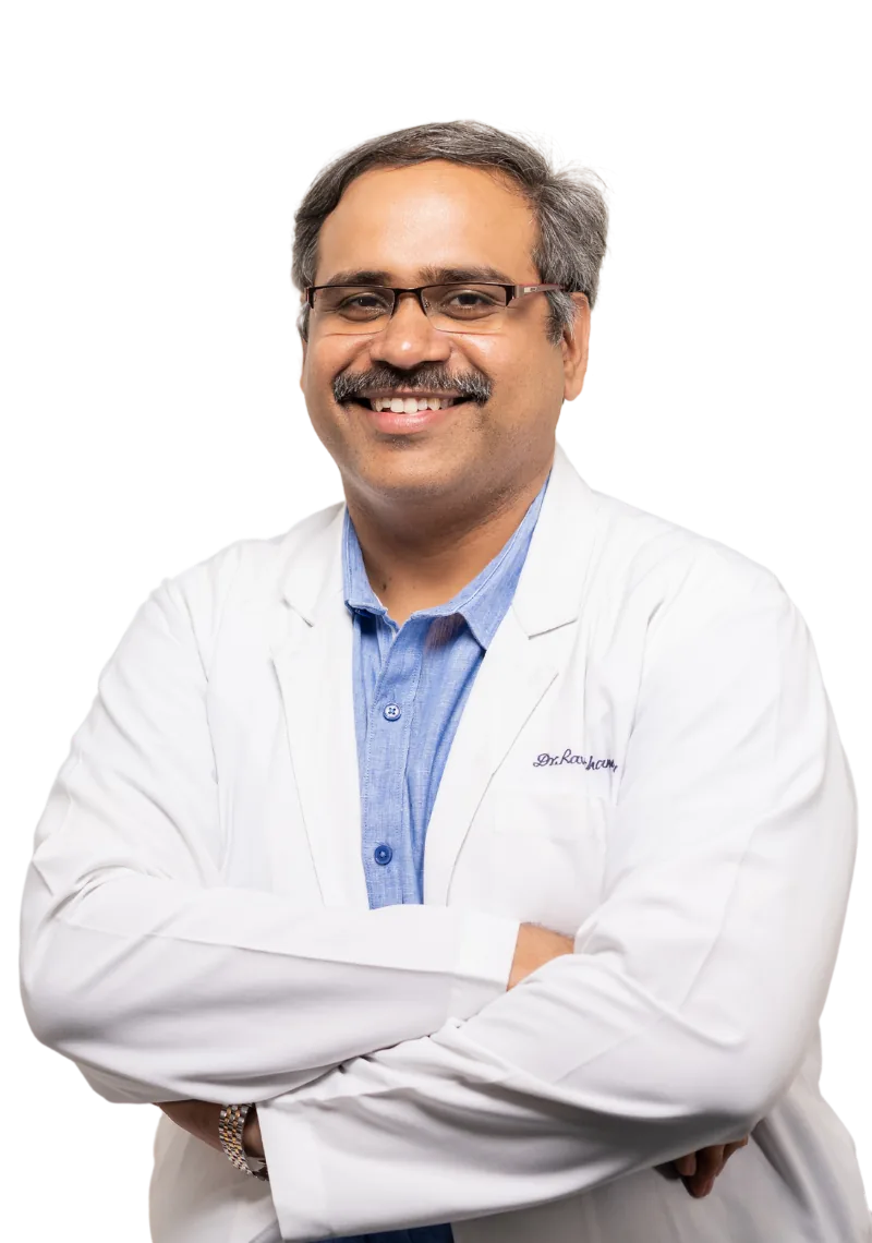 Dr Ravi Chandra Vattipalli, robotic knee surgeon, in a white coat with arms folded